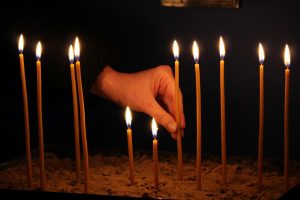 Hand with lit candle.