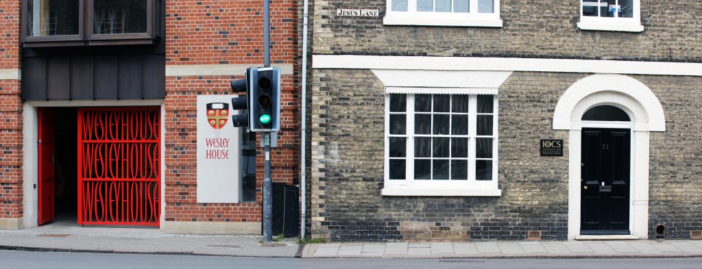 Image depicting entrance door to IOCS with window, plus entrance to Wesley House.